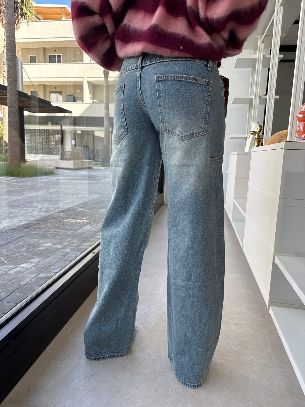 Jeans con bottone asimmetrico